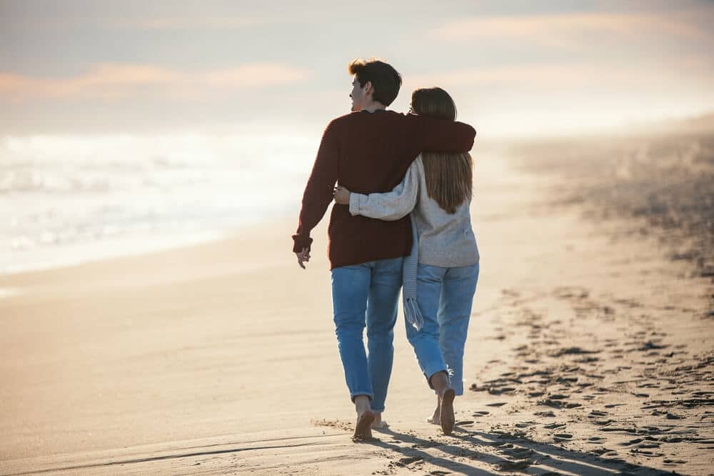 A couple walking on the beach on a winter vacation to Tybee Island, Georgia.