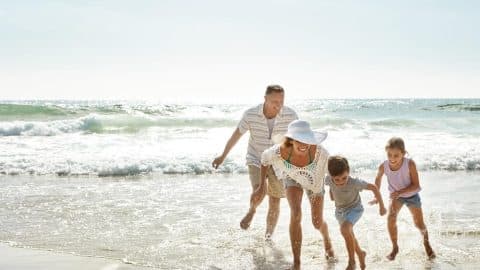 A family on the beach, one of the best Tybee Island summer activities.