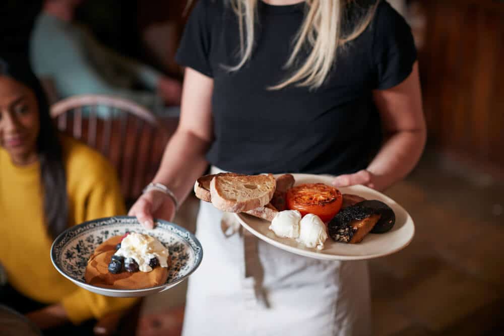 A waitress holding plates at a Tybee Island breakfast restaurant.