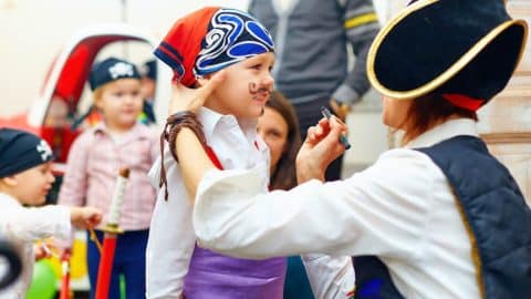 A kid getting face paint at the Tybee Island Pirate Fest.